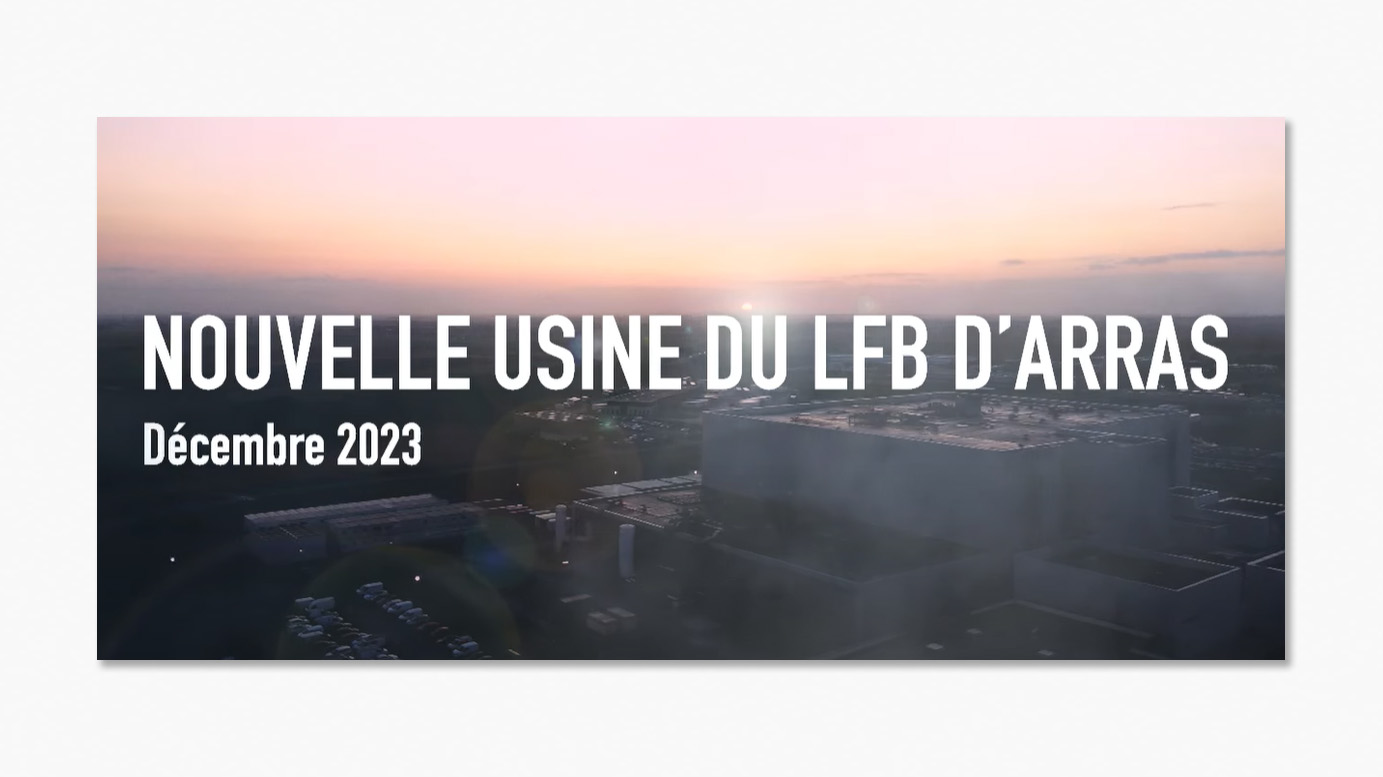 Vue aérienne de la nouvelle usine du LFB à Arras en décembre 2023, avec des bâtiments modernes au lever ou coucher du soleil.