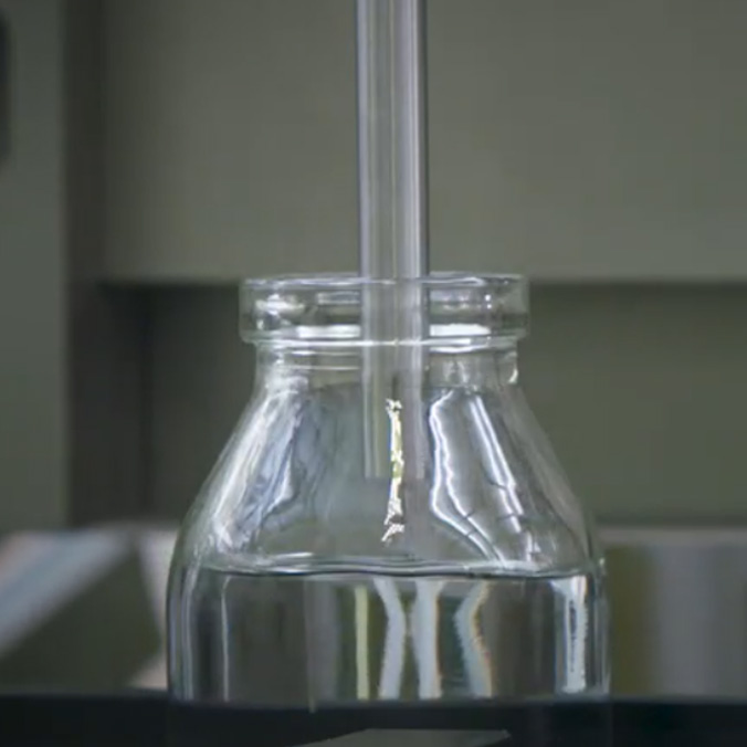 Bouteille en verre avec liquide et tube, en laboratoire