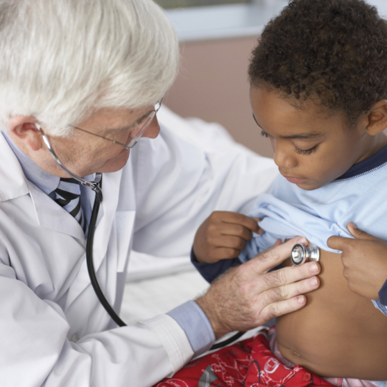 Un médecin auscultant un enfant avec un stéthoscope.