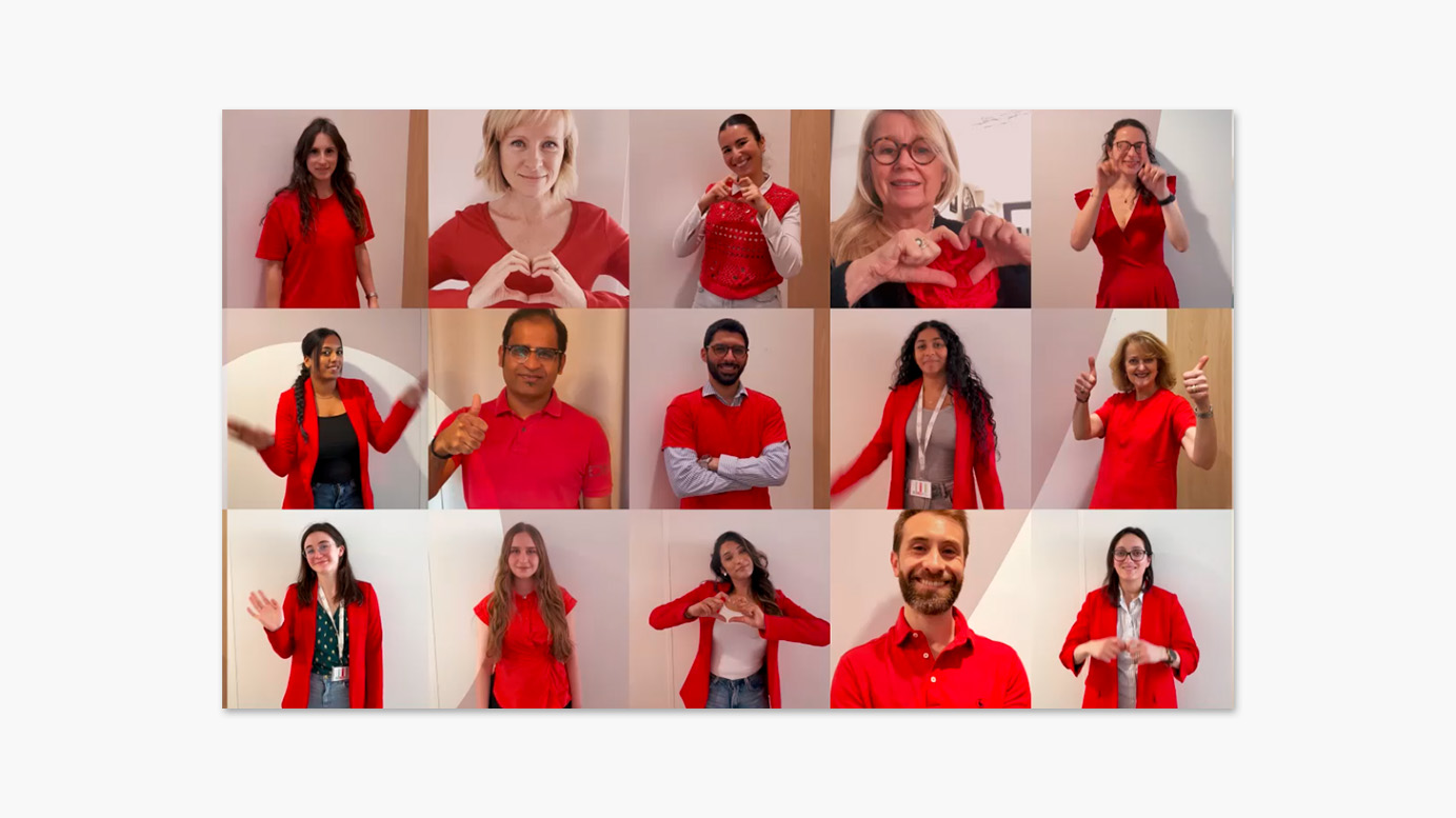 Mosaïque de quinze photos de personnes différentes portant des vêtements rouges, chacune formant un cœur avec ses mains ou faisant un signe de la main, dans le cadre d'une campagne de sensibilisation.
