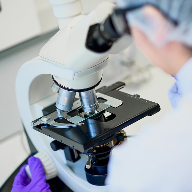 Chercheur en laboratoire utilisant un microscope